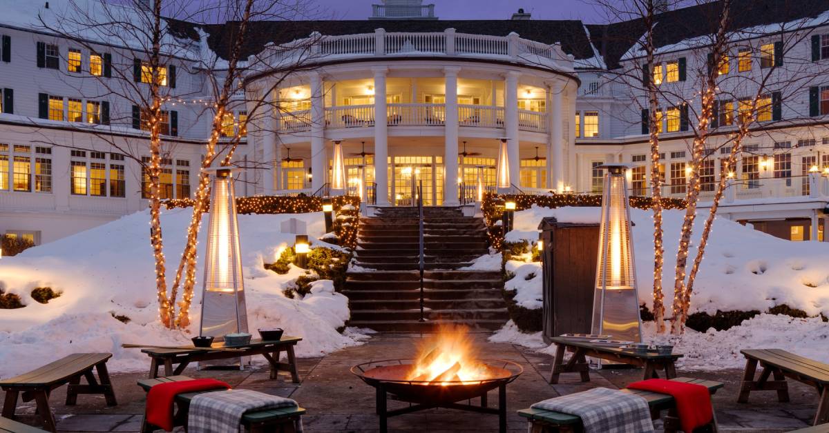 exterior of sagamore hotel in winter with holiday lights and fire pit