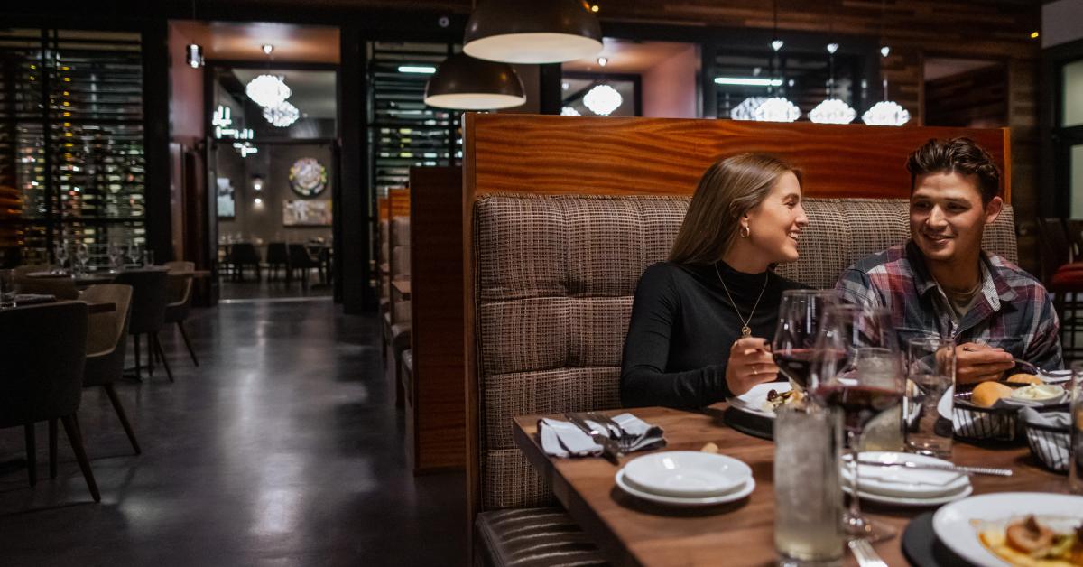 man and woman seated next to each other at restaurant booth