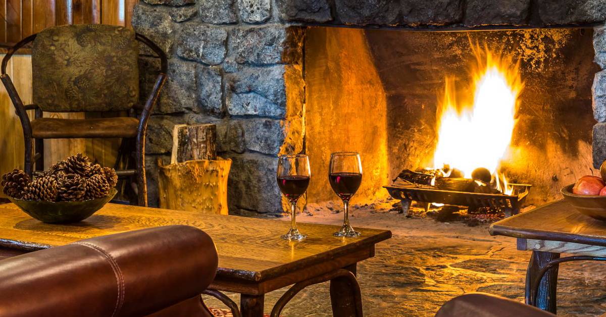 two glasses of wine by the fire