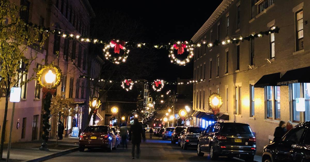 holiday wreaths over a city street at night