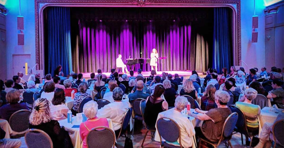two people on stage at a concert hall