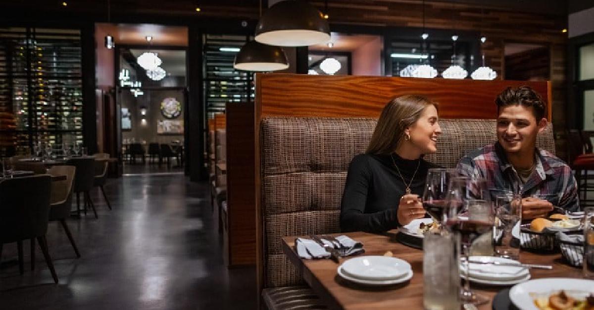 two people in booth laughing over dinner