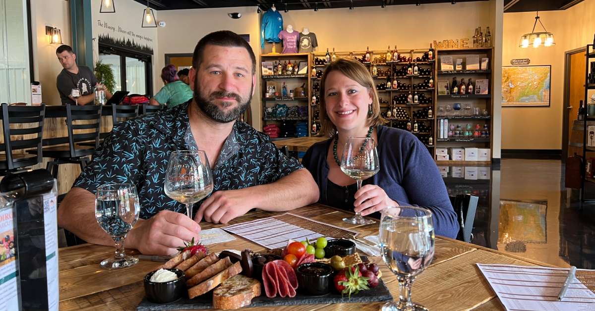 man and woman seated together at a table in a winery tasting room