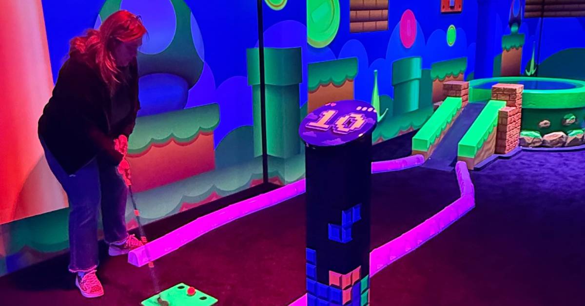 woman plays indoor mini golf at adk karting