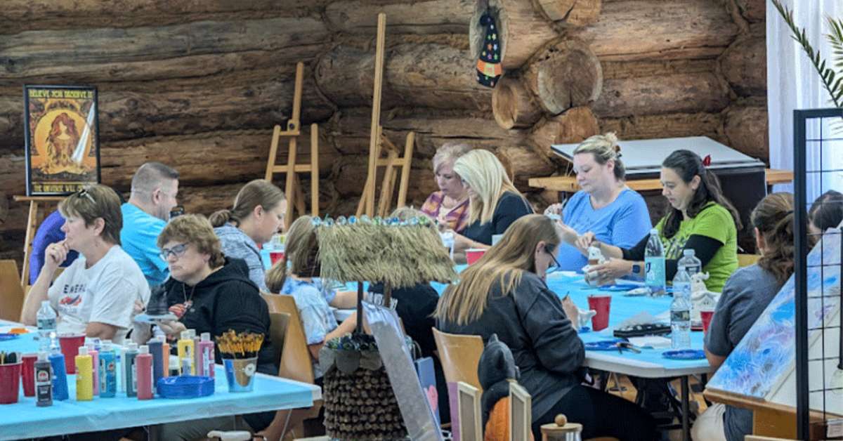 people working on artworks in rustic cabin space