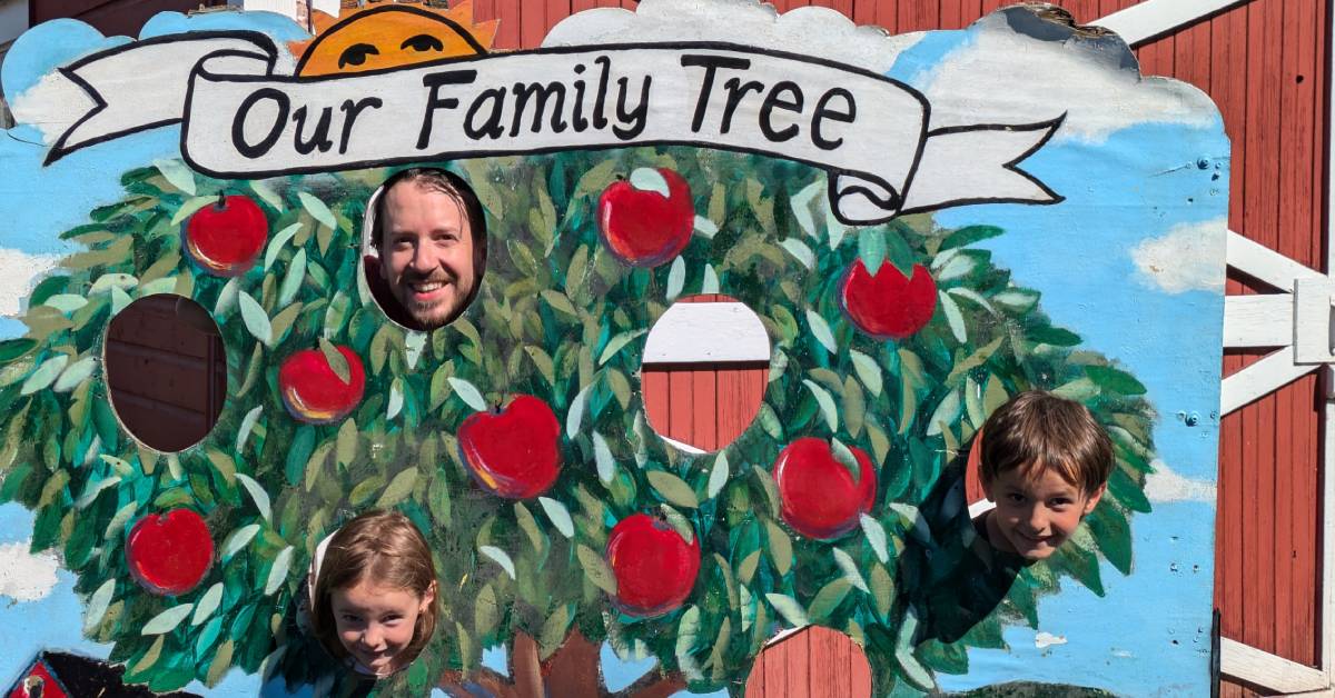 dad poses with kids in photo op at hicks orchard with family tree