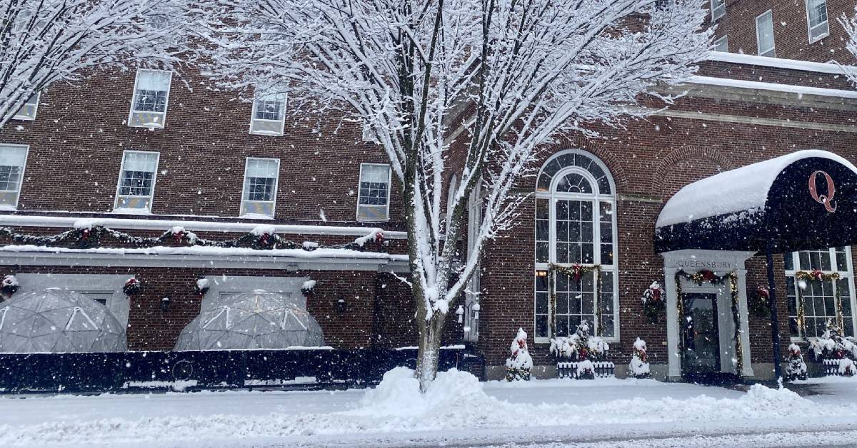 exterior of queensbury hotel with dining igloos set up