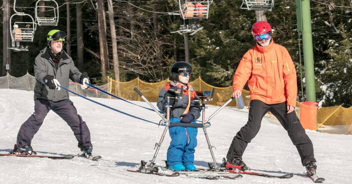 two adults with a child on ski slope