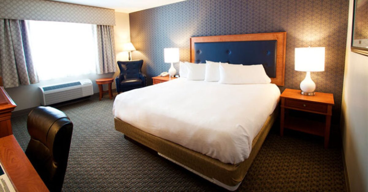 hotel bedroom with a bed, tables, and lamps
