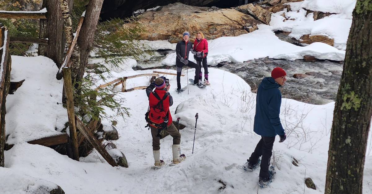 people snowshoeing at natural stone bridge and caves