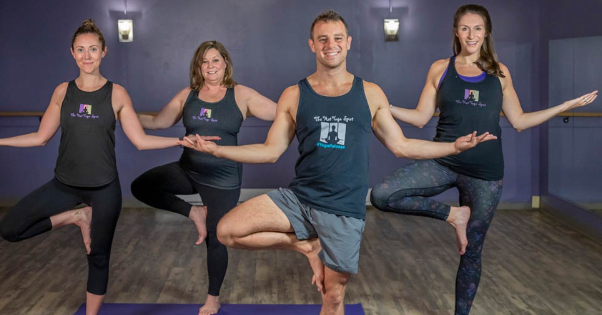 three women and a man doing hot yoga