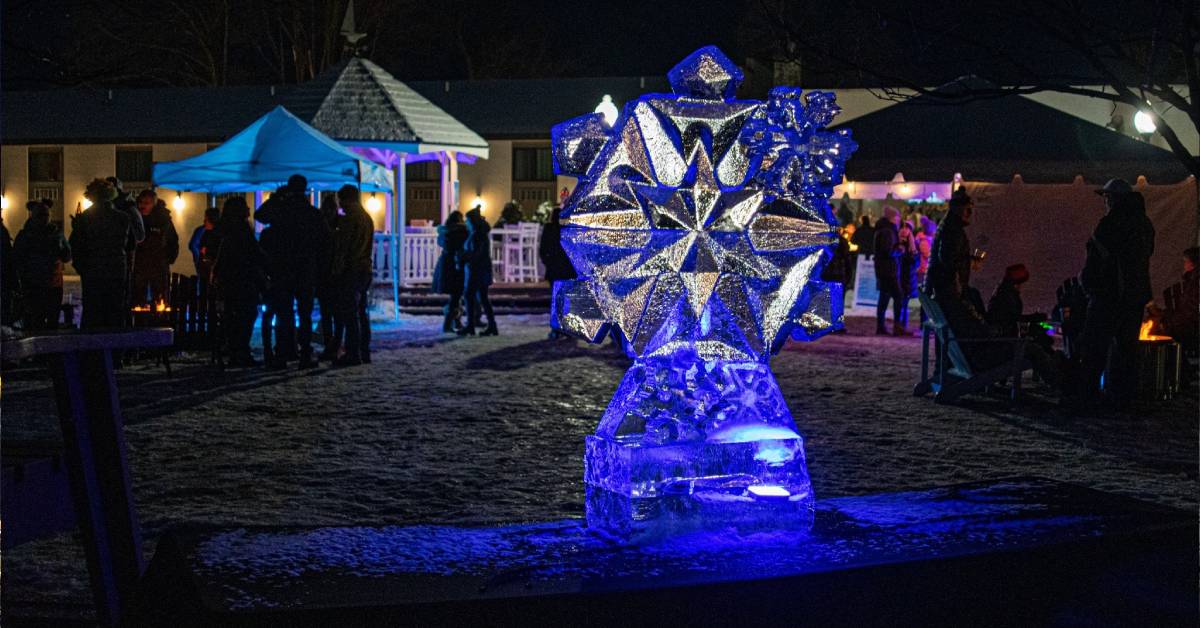 an ice bar statue at night and crowds of people