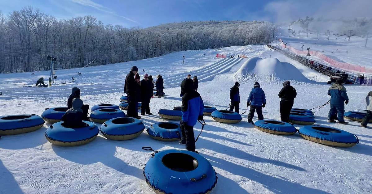 people gathering with snow tubes