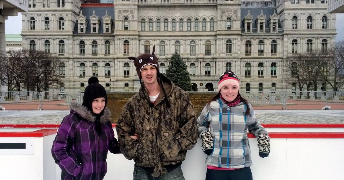 three ice skaters pose at the empire skate plaza in albany