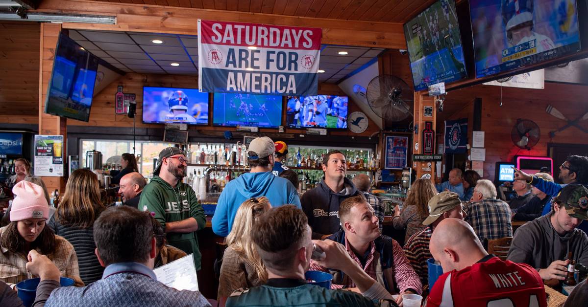 interior of lake george beach club with football games on