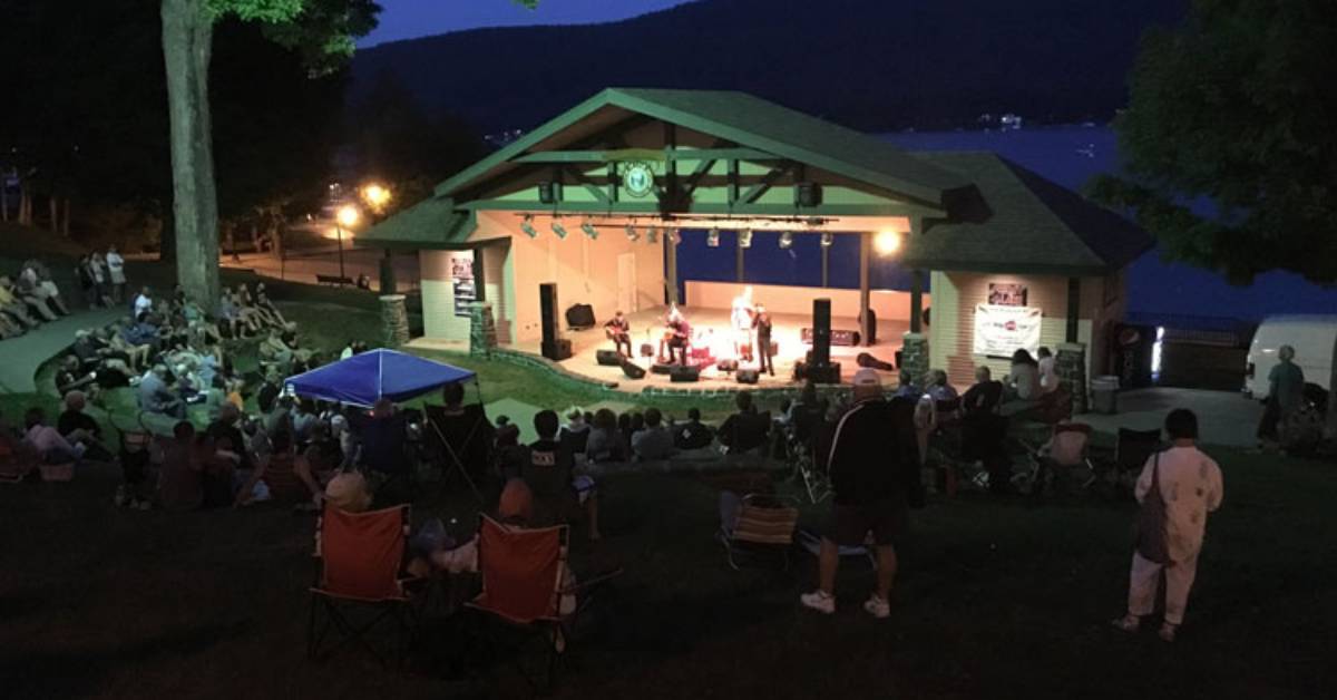 people watching concert at amphitheater during the evening