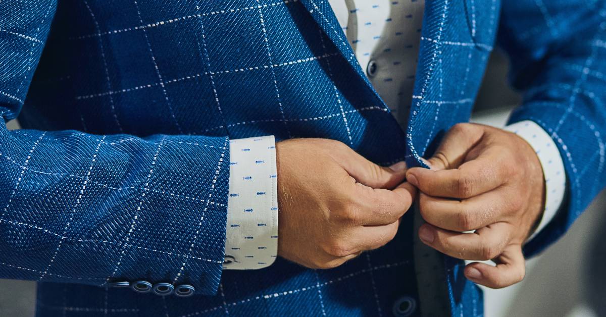 closeup of man buttoning suit jacket