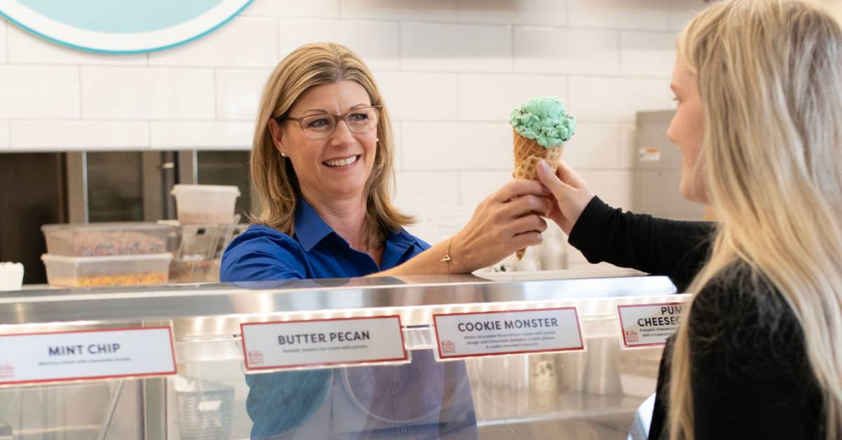 woman handing another woman an ice cream cone