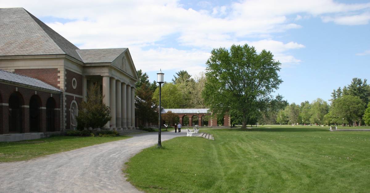 gravel walkway by a brick building in a park
