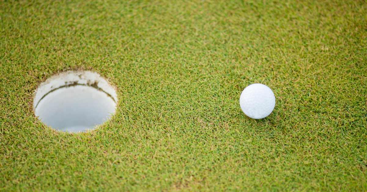 white golf ball near a hole