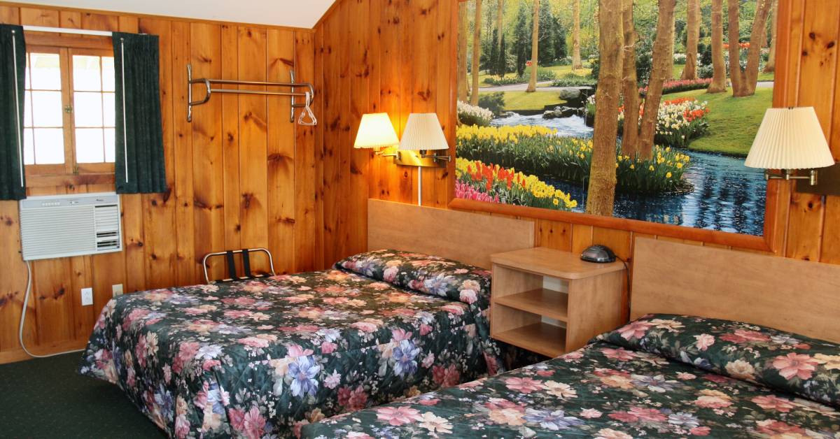 two beds with floral comforters in motel
