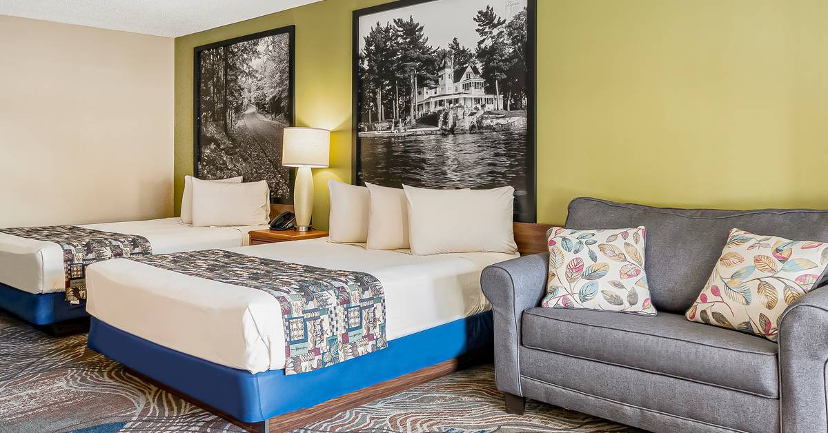 two beds and small couch in hotel room