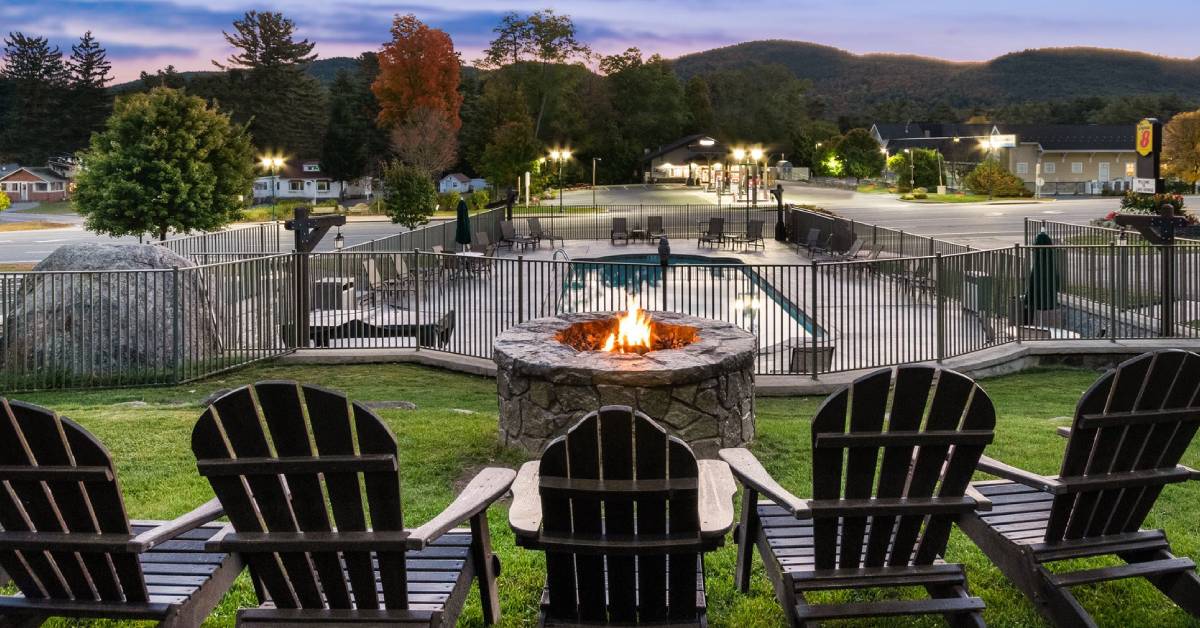 fire pit with adirondack chairs in front of hotel pool