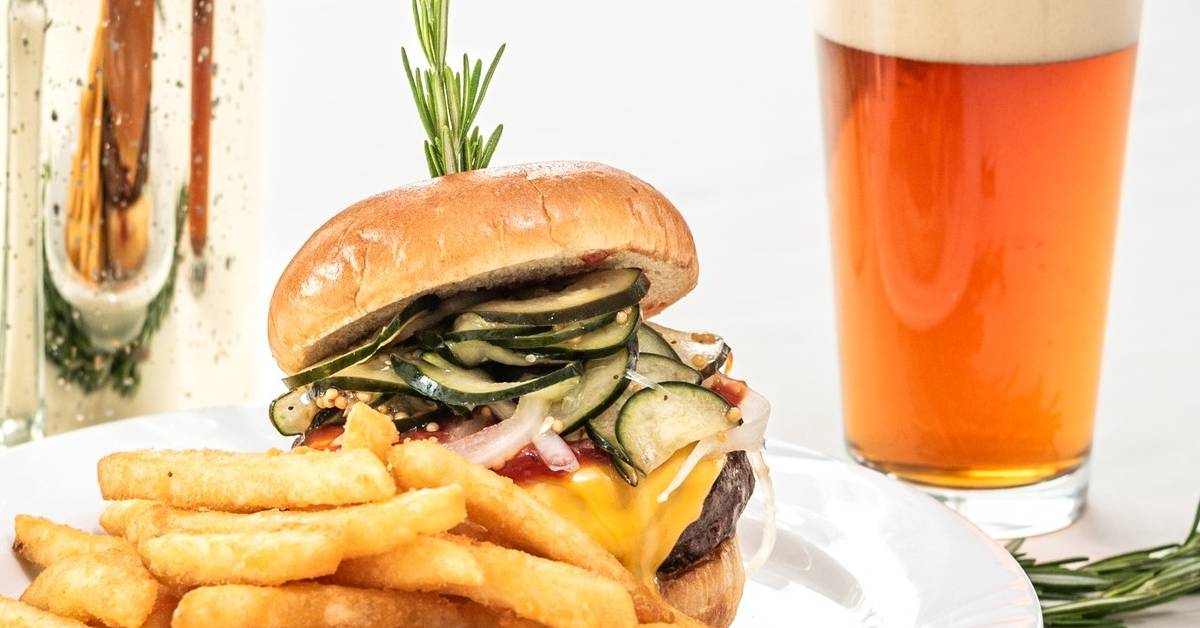 burger with lots of pickles and a beer