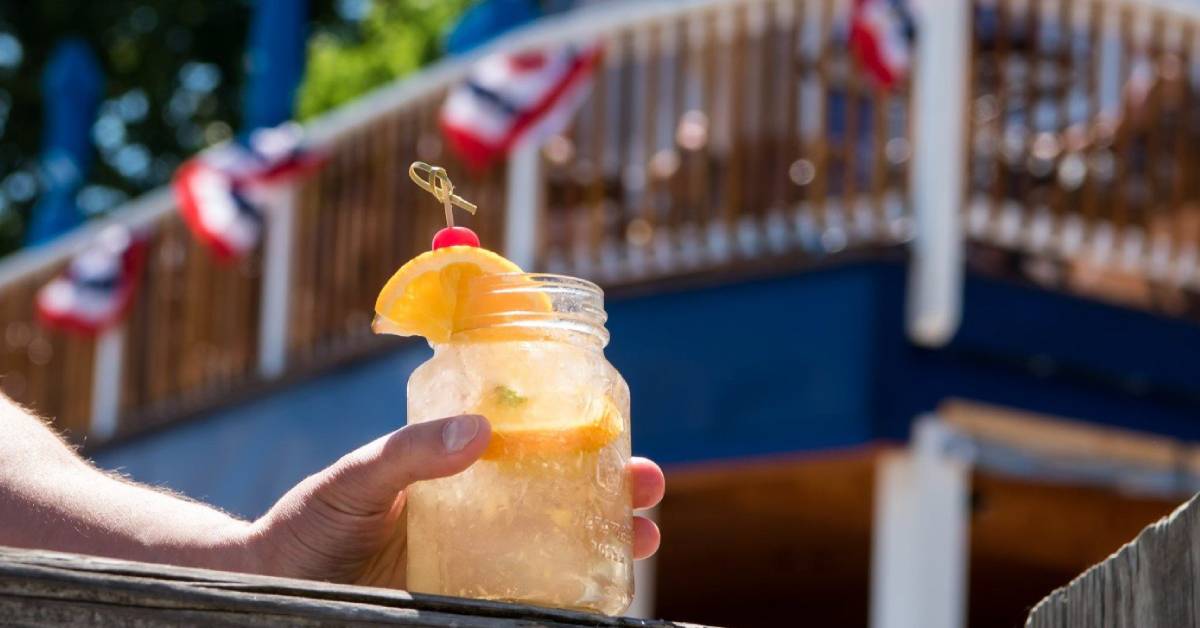hand holding cocktail on patio