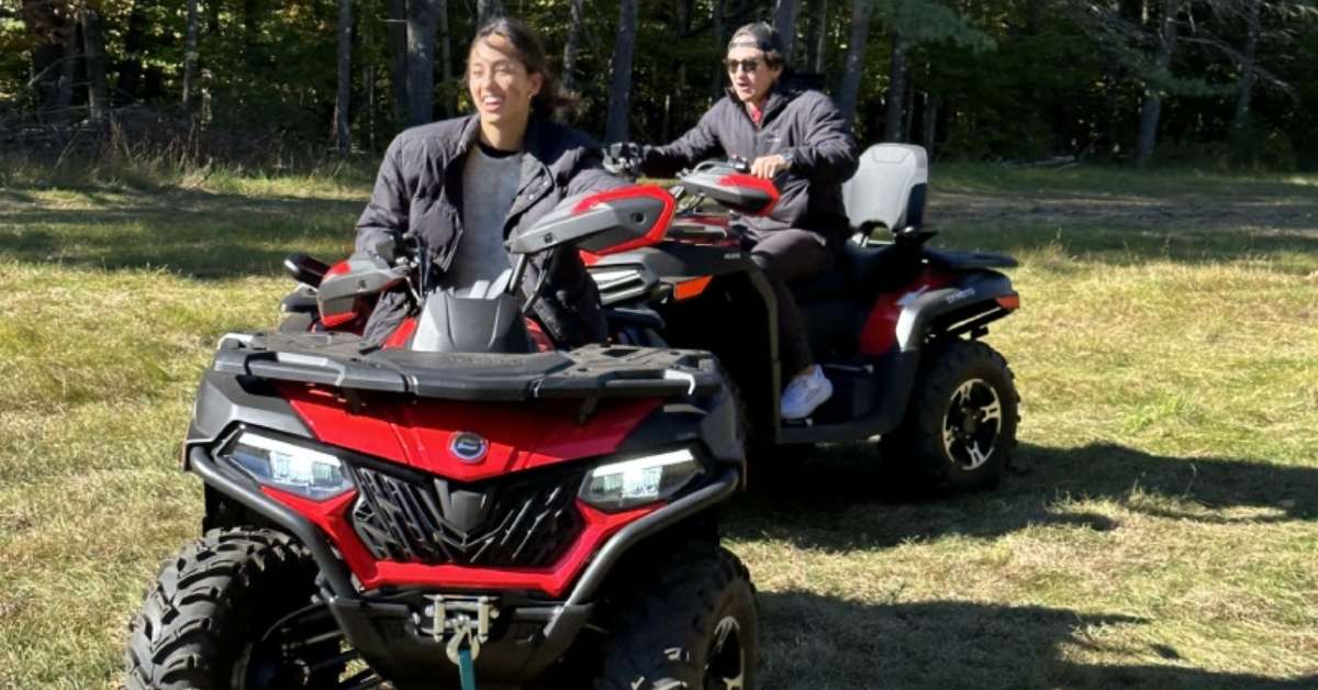 two people riding ATVs