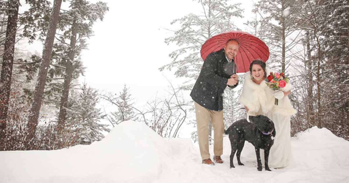 A couple poses in the snow