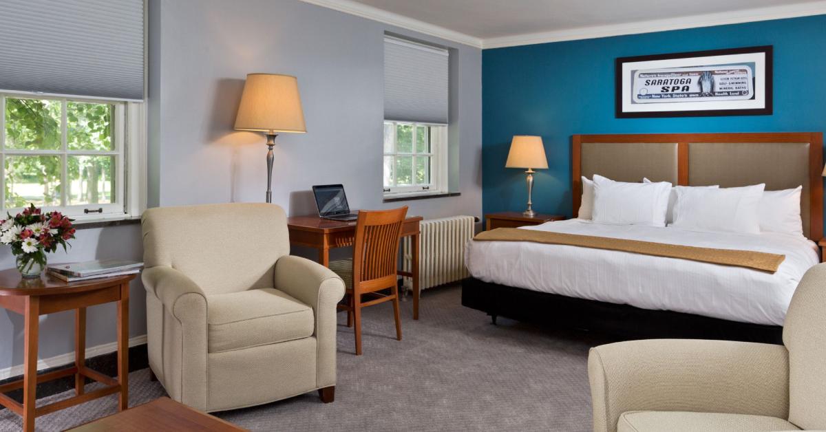 hotel room with a large bed and sofa chairs
