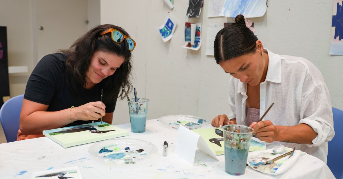 two women painting at a table