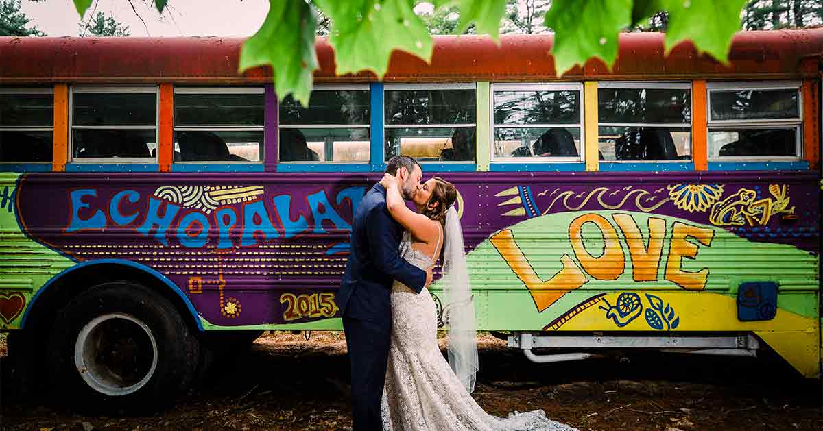 A couple poses in front of a 60s-inspired bus at Jimbo's Club.