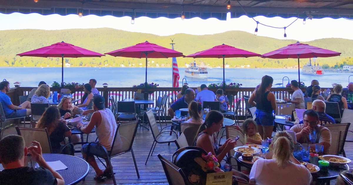 people dining on a patio with a view of the lake