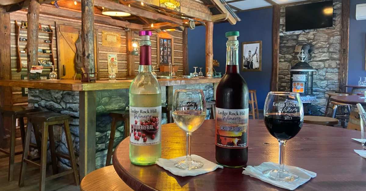 wine bottles and glasses on a table in a rustic tasting room