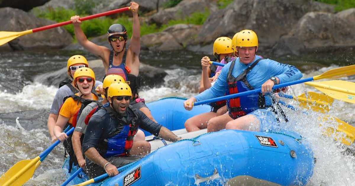 group of people whitewater rafting in blue raft