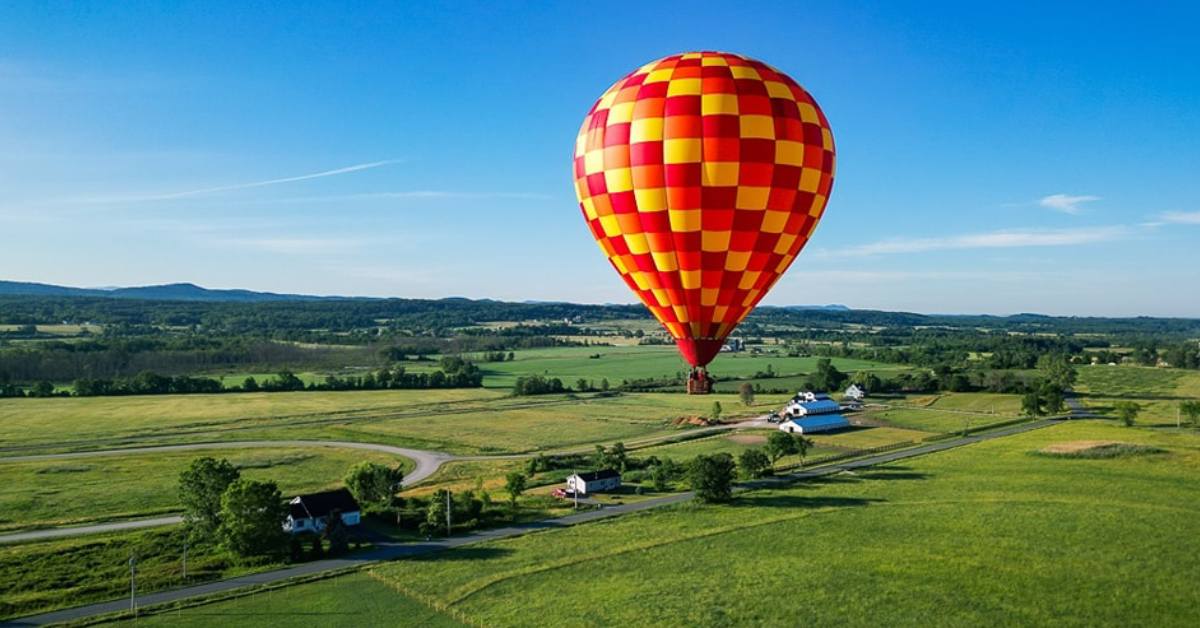 red and yellow hot air balloon above the countryside