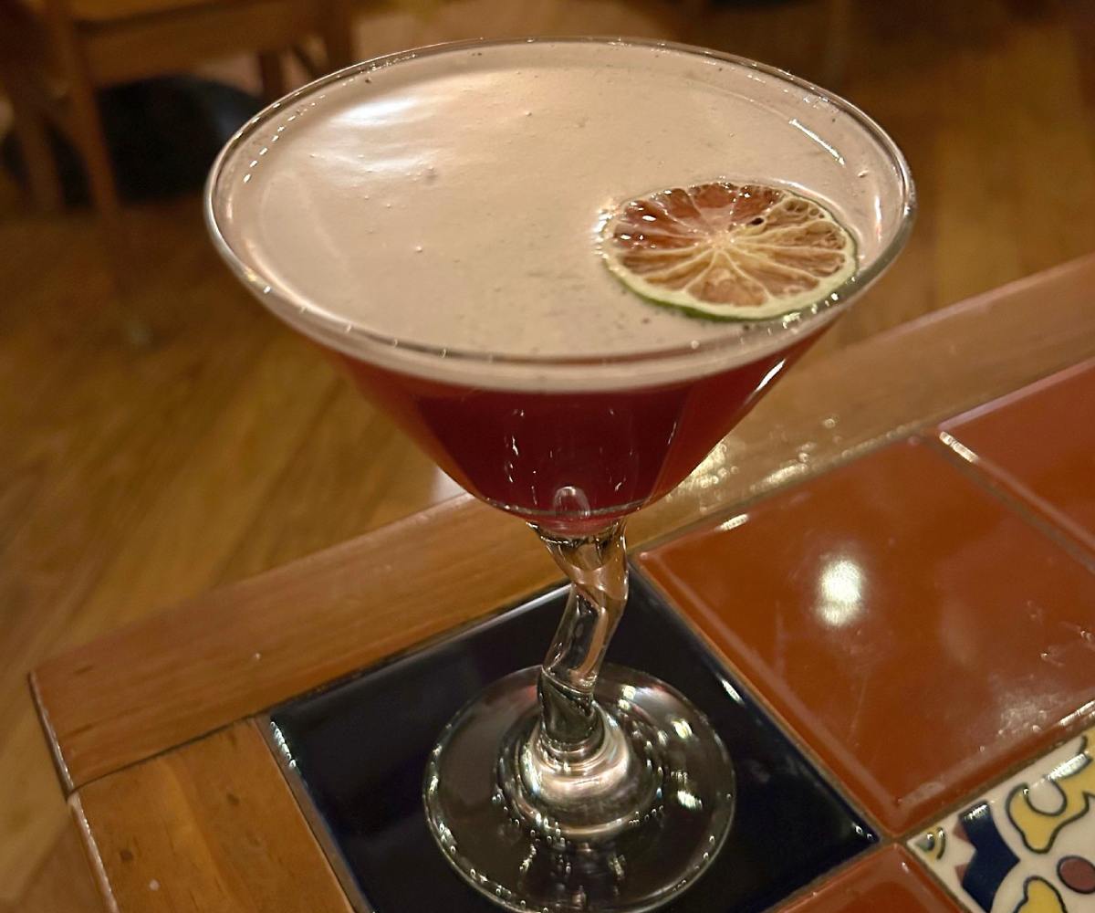 a dark red cocktail on a table