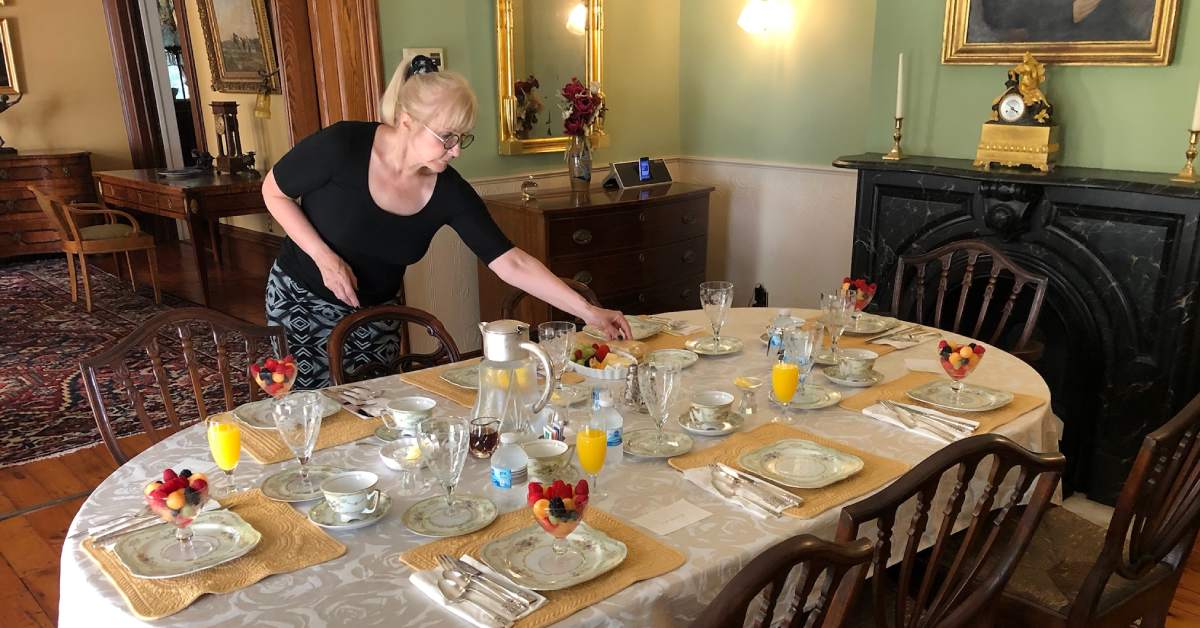 woman preparing breakfast table at a B&B