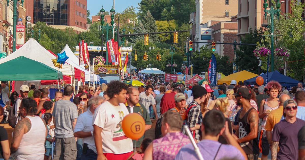 people walking around an outdoor street festival