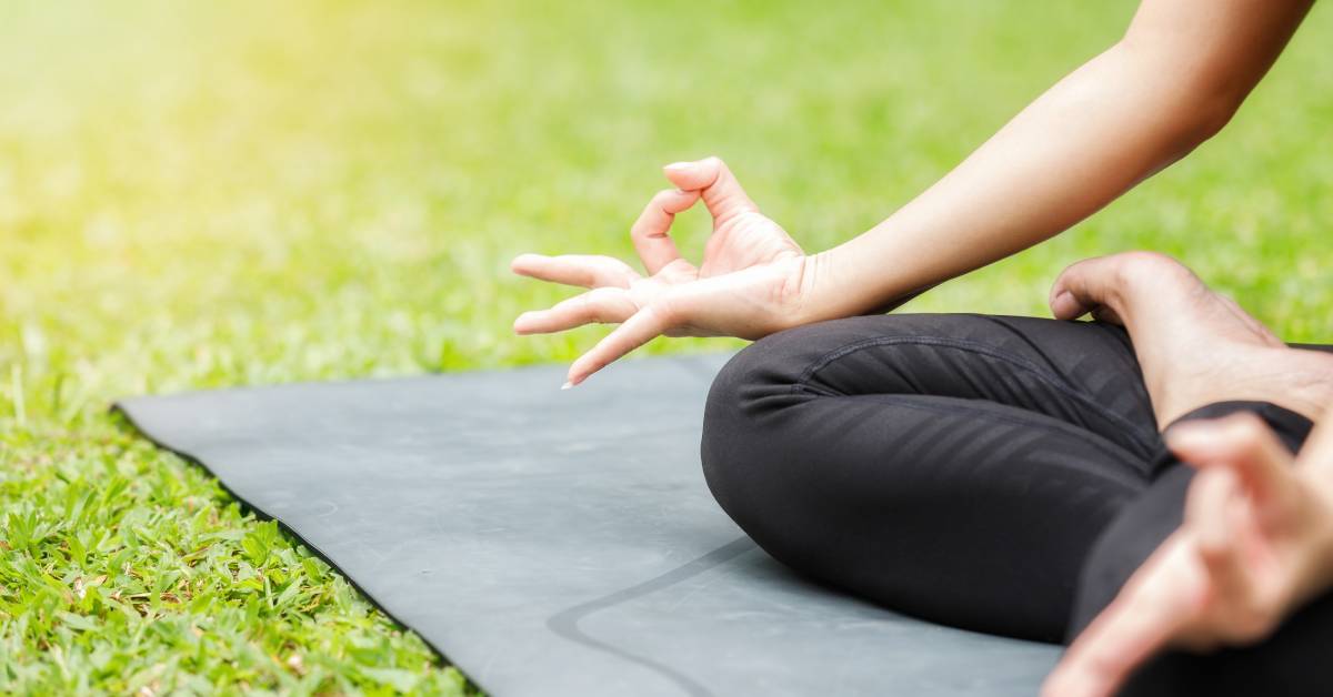closeup of woman doing lotus pose outdoors