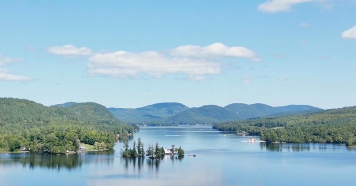 a calm lake with mountains in the distance