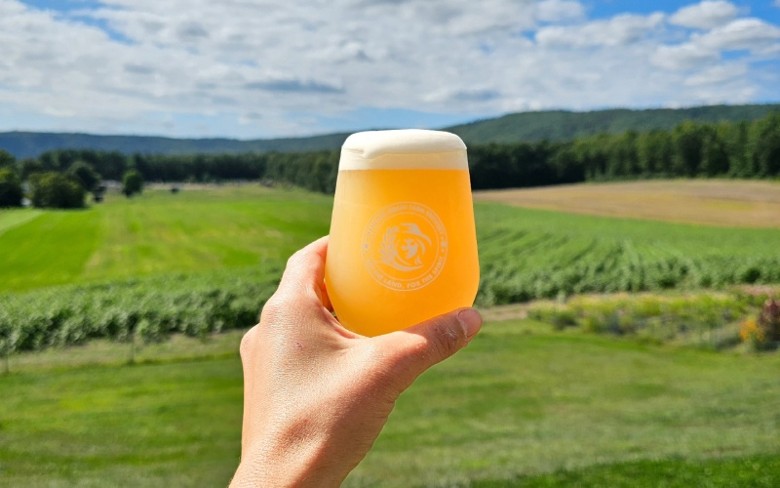 Beer Being held up a field 