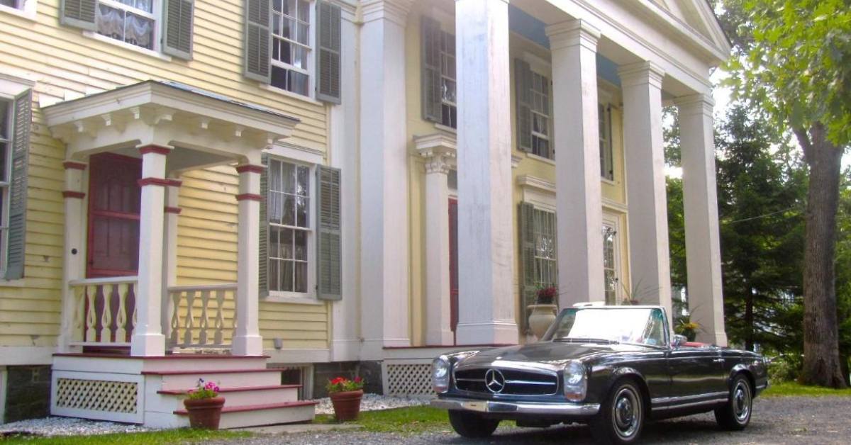 exterior of yellow inn with classic car near the door