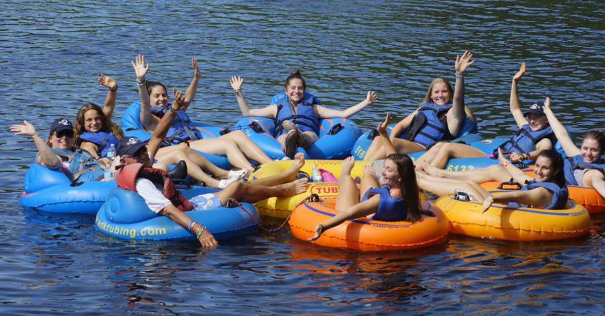 people in blue and orange tubes on a river