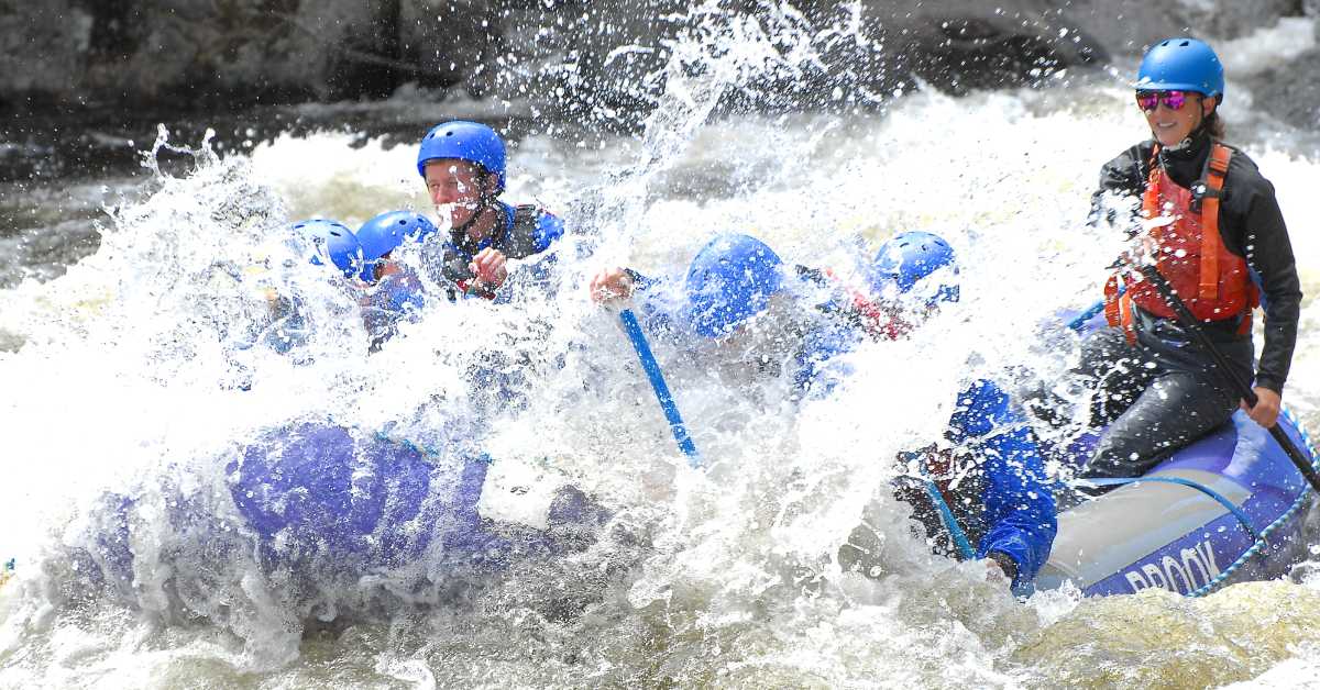 group of rafters getting splashed by water