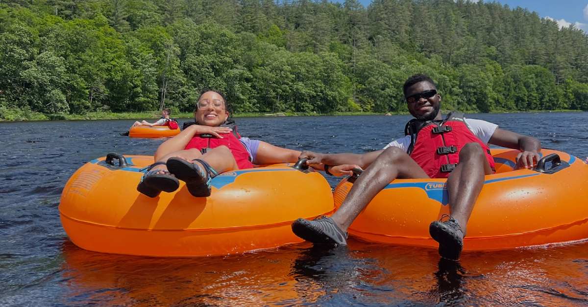 man and woman on large orange tubes