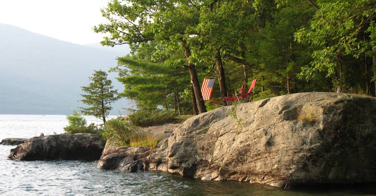 island on lake george with chairs and flag