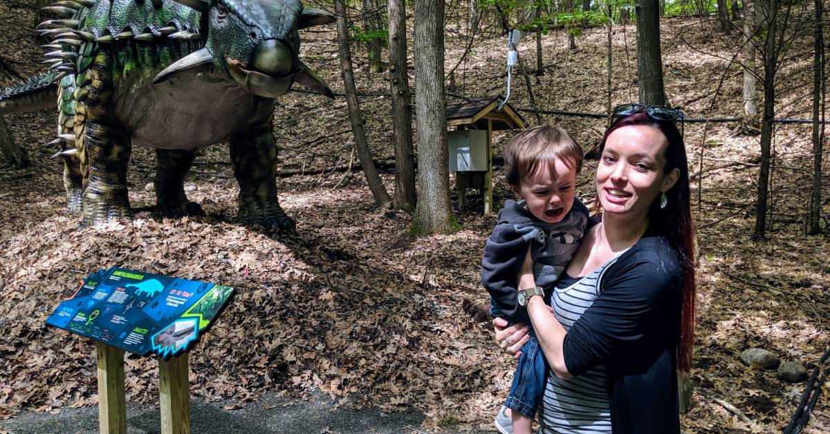 pregnant lady with crying toddler by dinosaur
